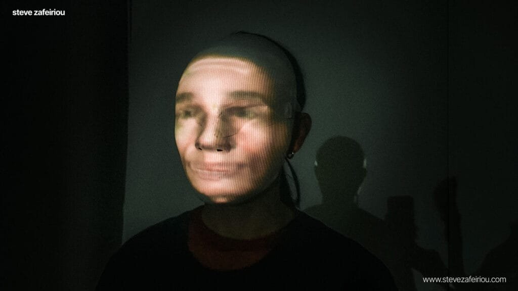 Plan Interactive Art Experience: Real-time body projection mapping experiment by Steve Zafeiriou, showcasing innovative digital art techniques with facial projections and immersive visual effects in a dark environment.