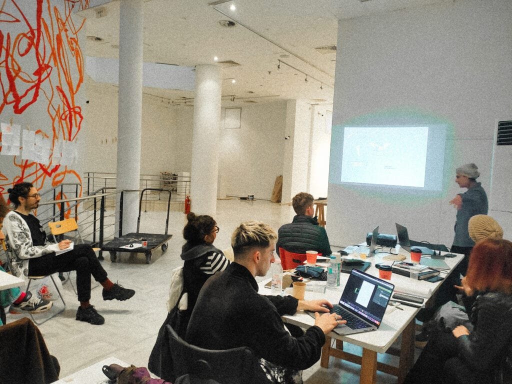 Arduino Art Projects: Workshop from Inspire Project 2023 workshop held at the MOMus Museum of Contemporary Art in Thessaloniki, Greece, engaging in collaborative learning with laptops and presentations in a creative, modern space.