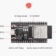 ESP32 Pinout Guide: ESP32 DevKit V4 board featuring ESP32-WROOM-32 module with labeled components such as EN button, boot button, micro USB port, I/O connectors, USB-to-UART bridge, and power indicator LED.