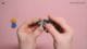 Hands demonstrating a small 2-axis joystick module, used in DIY arcade consoles and game controllers.
