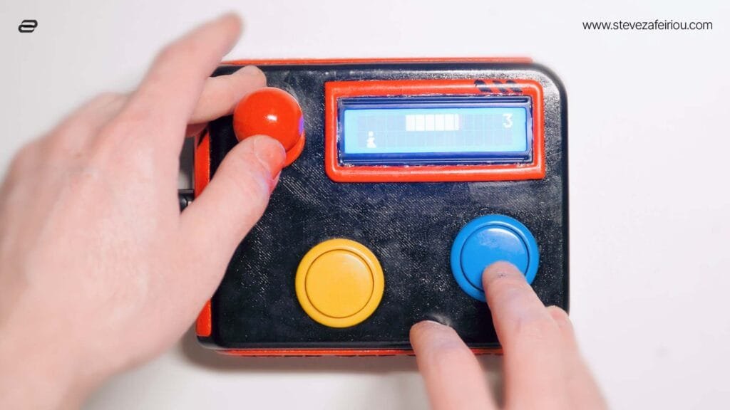 Hands playing on a DIY Arduino-based arcade console with joystick, buttons, and an LCD screen displaying game graphics.