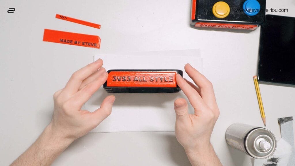 Hands assembling and gluing custom-designed, red and black 3D-printed parts for a personalized arcade console labeled '3VS3 ALL STYLE'.