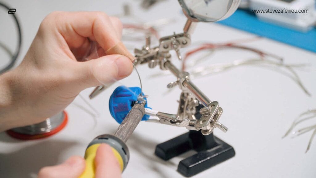 Hands-on soldering of a mini arcade button for a custom gaming console, demonstrating DIY electronics and arcade component assembly.
