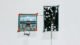 Interactive art installation titled 'Synthetic Memories' by Steve Zafeiriou, showcasing a digital memory network on a vertical screen connected to a curated set of vintage images and a handheld interface.