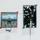 Interactive art installation titled 'Synthetic Memories' by Steve Zafeiriou, showcasing a digital memory network on a vertical screen connected to a curated set of vintage images and a handheld interface.
